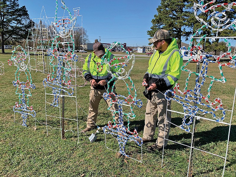 City of Batesville landscaping department employees Donald McIllwain, left, and Timothy Duez work on a lighting display of elves at White River Wonderland. Lights go on the day before Thanksgiving. A new attraction this year is a 70-foot-tall LED Ferris wheel that is to be located near the amphitheater. Tickets to ride are $5 and must be purchased online. 