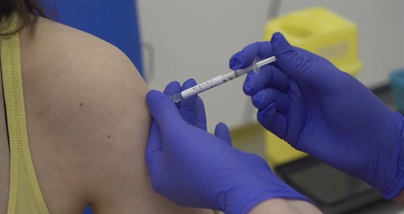 FILE - In this Thursday, April 23, 2020 file screen grab taken from video issued by Britain's Oxford University, showing a person being injected as part of the first human trials in the UK to test a potential coronavirus vaccine, untaken by Oxford University in England.