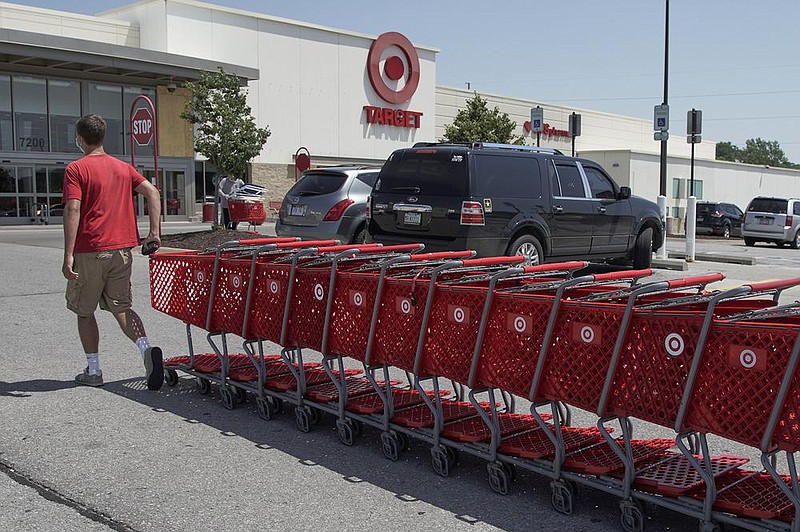 A Target employee collects shopping carts from the parking lot and returns them to the store in Omaha, Neb., in June. The Minneapolis-based retailer reported Wednesday an online sales surge in the three months that ended Oct. 31.
(AP)