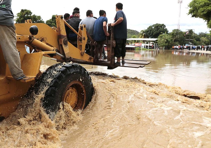 A heavy lifter carries people across a flooded area in La Lima, Honduras, on Wednesday in the aftermath of Hurricane Iota.
(AP/Delmer Martinez)