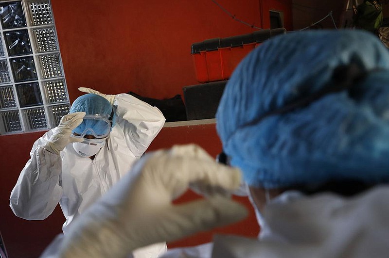 Doctors Delia Caudillo (left) and Monserrat Castaneda put on protective gear Thursday as they prepare to conduct a covid-19 test at a home in the Venustiano Carranza borough of Mexico City.
(AP/Rebecca Blackwell) story.lead_photo.caption