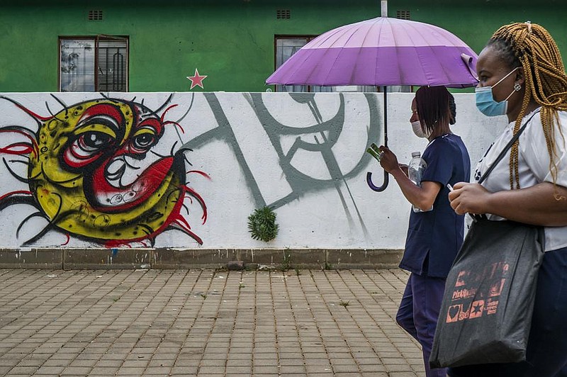 Two women walk past covid-19 graffiti Thursday in Soweto’s Orlando West township near Johannesburg, South Africa. Africa has surpassed 2 million confirmed coronavirus cases as the continent’s top public health official warns that “we are inevitably edging toward a second wave” of infections. More photos at arkansasonline.com/1120covid/.
(AP/Jerome Delay)