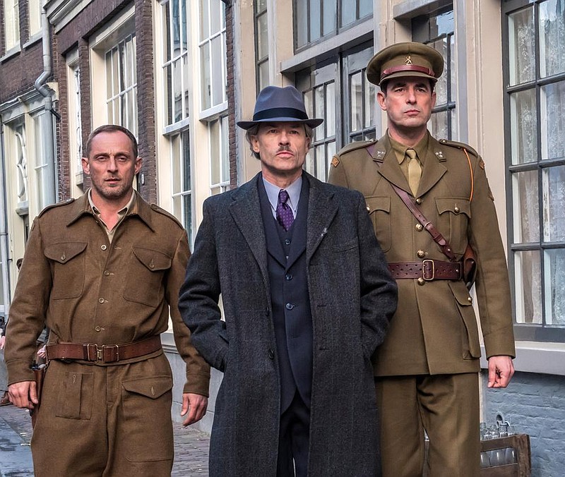 Dutch artist Han Van Meegeren (Guy Pearce, center) is escorted by Capt. Joseph Piller (Claes Bang, right) an Allied officer in post-World War II Holland tasked with investigating whether Meegeren conspired with the Nazis in “The Last Vermeer.”