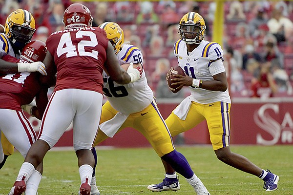 LSU quarterback TJ Finley (11) looks to pass as Arkansas defensive lineman Jonathan Marshall (42) pressures him during a game Saturday, Nov. 21, 2020, in Fayetteville. (AP Photo/Michael Woods)