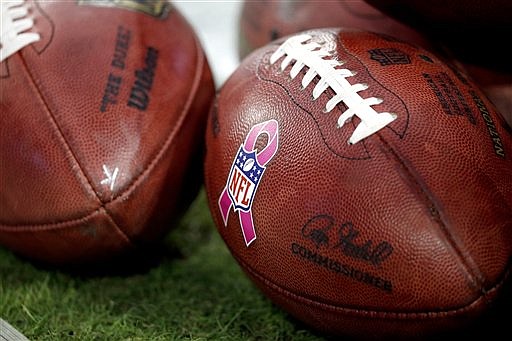 Footballs sporting the NFL Breast Cancer Awareness pink ribbon sit on the field prior to a football game in this Oct. 23, 2016, file photo.