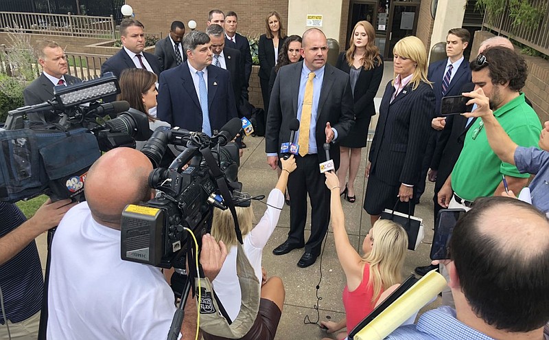 Duane "Dak" Kees (center), then the U.S. Attorney for the Western District of Arkansas, speaks Wednesday, Sept. 5, 2018, alongside Assistant U.S. Attorney Kenneth Elser (left) after the sentencing hearing for former state Sen. Jon Woods outside the John Paul Hammerschmidt Federal Building in Fayetteville. Woods was sentenced to more than 18 years for his role in a kickback scheme involving state General Improvement Funds.