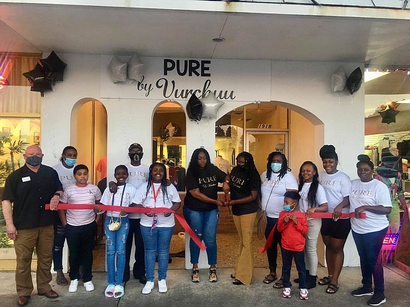 Kelsea Miner (left) and Chasity Johnson (right) cut the ribbon to new shop, Pure by Vurchuu, surrounded by close friends and family members. (Marvin Richards/News-Times)