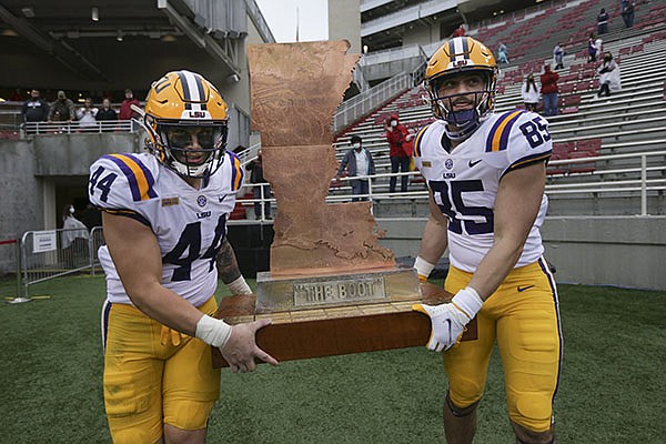 LSU players Tory Carter (44) and Nick Storz (85) carry The Boot after defeating Arkansas 27-24 on Saturday, Nov. 21, 2020, in Fayetteville.