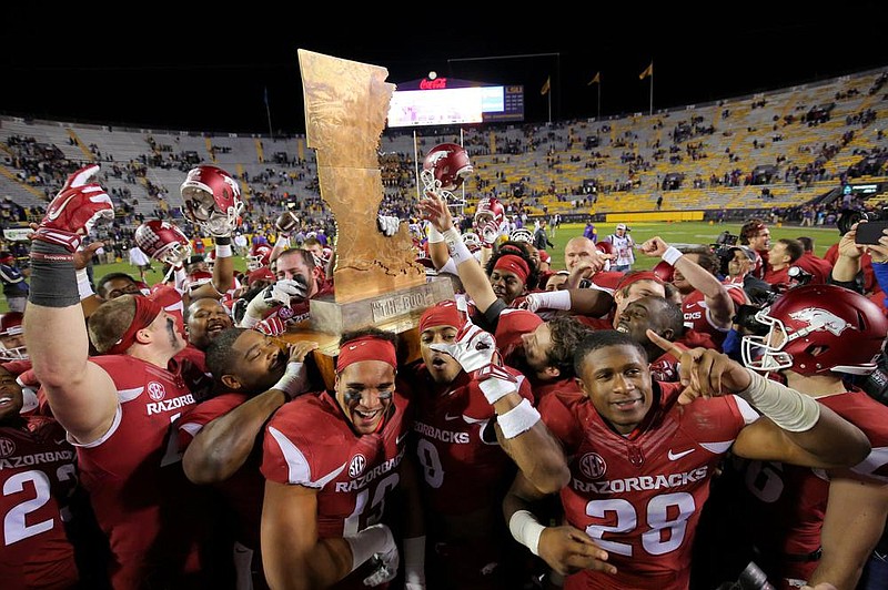 Arkansas players leave the field at Tiger Stadium in Baton Rouge with the Golden Boot trophy after defeating LSU 31-14 on Nov. 14, 2015. It was the last time the Razorbacks defeated the Tigers and took home the trophy entering today’s game in Fayetteville. No current Arkansas players have won against LSU.
(Democrat-Gazette fi le photo)
