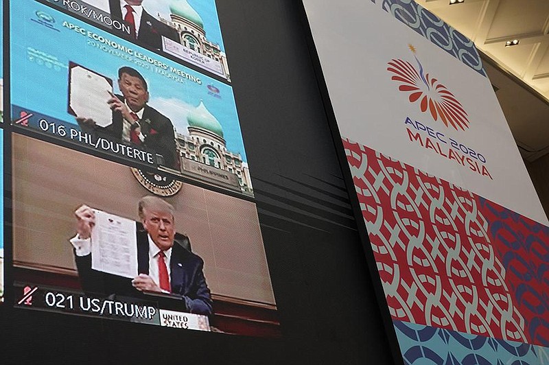 President Donald Trump and other world leaders hold up declarations Friday at the first virtual Asia-Pacific Economic Cooperation summit, hosted by Malaysia. Trump participated in the annual event for the first time since 2017.
(AP/Vincent Thian)