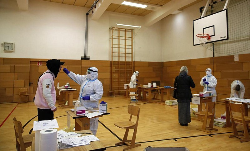 People are tested for the coronavirus Friday in a school set up as a testing facility in Bolzano, northern Italy. More photos at arkansasonline.com/1121italycovid/.
(AP/Antonio Calanni)