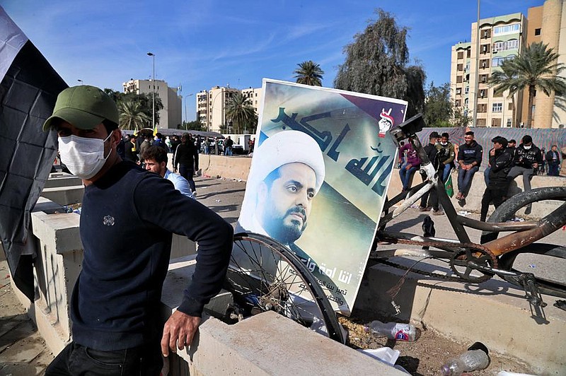 A supporter of pro-Iranian militiamen stands Jan. 1 near a poster of Qais al-Khazali, the leader of the militant Shiite group League of the Righteous, during a sit-in in front of the U.S. Embassy in Baghdad.
(AP/Khalid Mohammed) story.lead_photo.caption