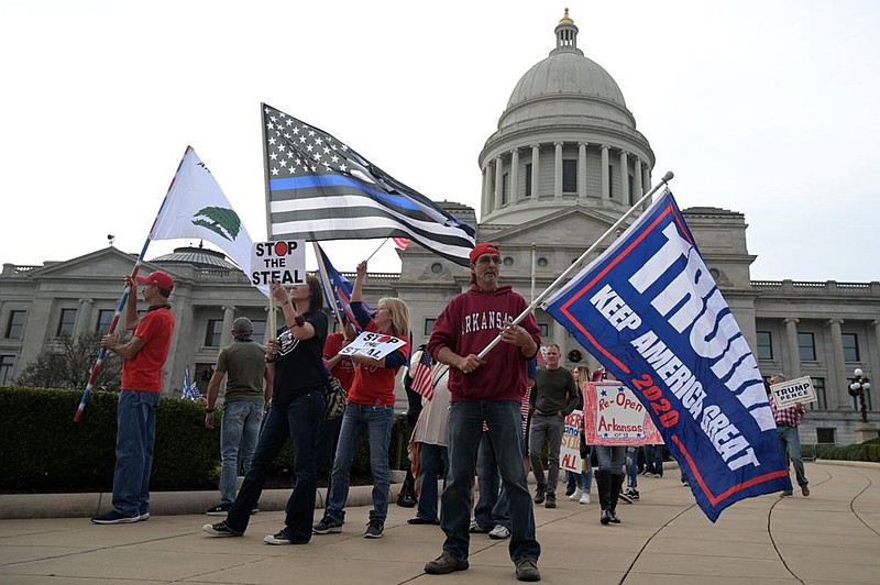 People supporting President Donald Trump and decrying alleged election fraud wave flags Saturday during a rally in front of the Arkansas state Capitol. More photos at arkansasonline.com/1122rally/. (Arkansas Democrat-Gazette/Stephen Swofford)