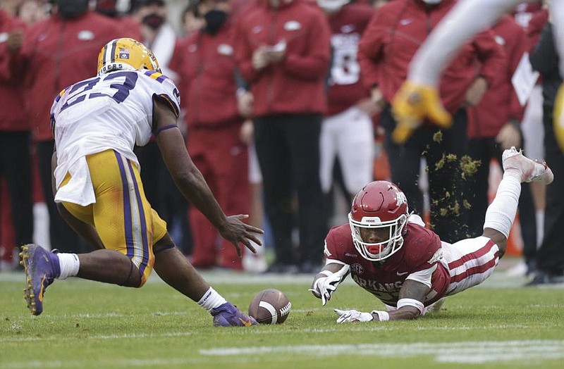 Arkansas running back Trelon Smith dives but can’t make a catch in front of LSU linebacker Micah Baskerville during the Razorbacks’ loss to the Tigers on Saturday at Reynolds Razorback Stadium in Fayetteville. It was Arkansas’ fifth consecutive loss to LSU. More photos available at arkansasonline.com/1122hogs.
(NWA Democrat-Gazette/Charlie Kaijo)