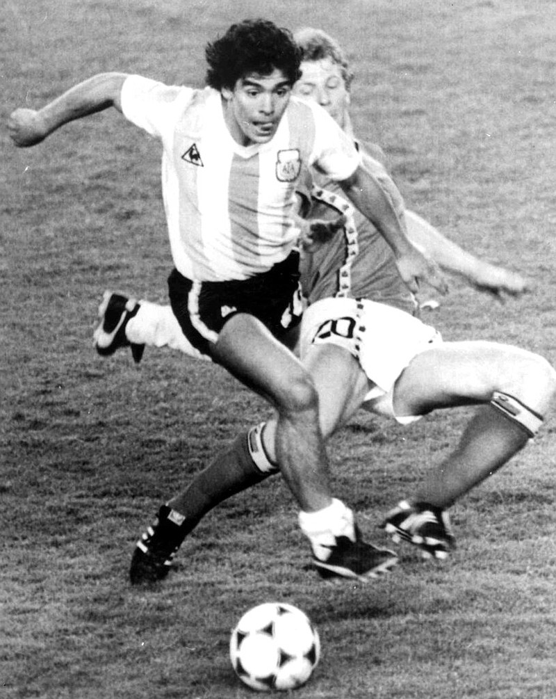 FILE - In this June 13, 1982 file photo, Argentina's Diego Maradona, front, is attacked by Belgium's Guy Vandermissen during the opening game of the Soccer World Cup in Barcelona, Spain. The Argentine soccer great who was among the best players ever and who led his country to the 1986 World Cup title before later struggling with cocaine use and obesity, died from a heart attack on Wednesday, Nov. 25, 2020, at home in Buenos Aires. He was 60. (AP Photo, File)