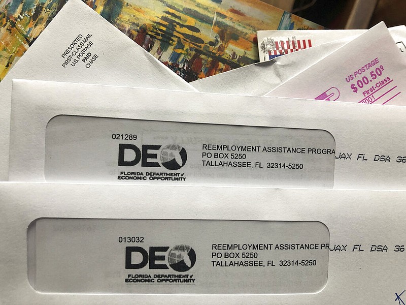 Envelopes from the Florida Department of Economic Opportunity Reemployment Assistance Program are shown, Thursday, Nov. 5, 2020, in Surfside, Fla.