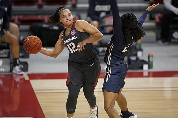 Arkansas guard Destiny Slocum (12) passes around an Oral Roberts defender during a game Wednesday, Nov. 25, 2020, in Fayetteville. 