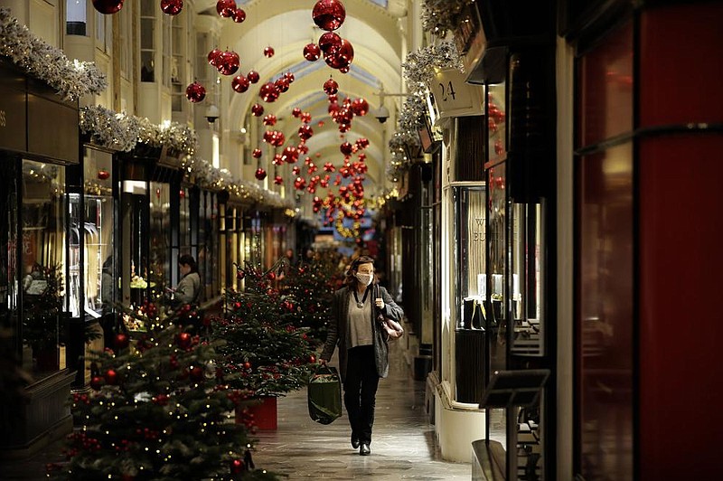 A woman walks past Christmas trees and decorations Wednesday in London’s Burlington Arcade, where all nonessential shops are temporarily closed.
(AP/Matt Dunham)