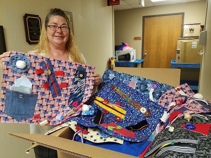 Sarah Carlisle, a Central Arkansas Veterans Healthcare System volunteer services specialist, unpacks the blankets the agency recently received. 
(Special to The Commercial)