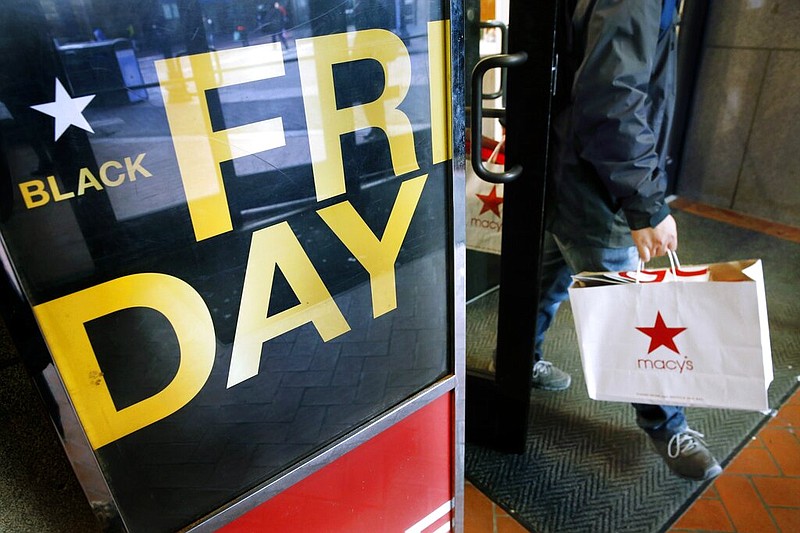 FILE - In this Nov. 29, 2019 file photo, a shopper leaves Macy's in Boston on Black Friday. (AP Photo/Michael Dwyer, File)


