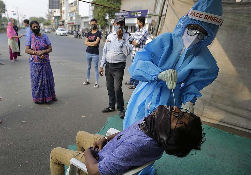 A health worker takes a nasal swab sample for a coronavirus test Wednesday at a facility set up in Ahmedabad, India. India has more than 9 million cases of covid-19, behind only the United States.
(AP/Ajit Solanki)