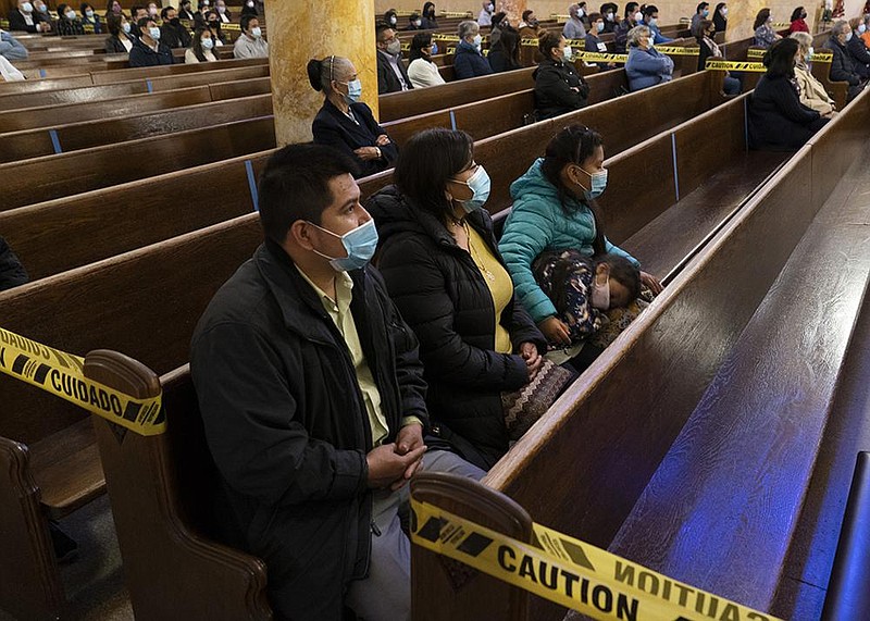 Congregants sit in distanced groups at a service at St. Agatha Church in Brooklyn, N.Y., in late October. New York’s strict limitations on religious services violate the First Amendment, the U.S. Supreme Court said in a ruling late Wednesday.
(The New York Times/James Estrin)