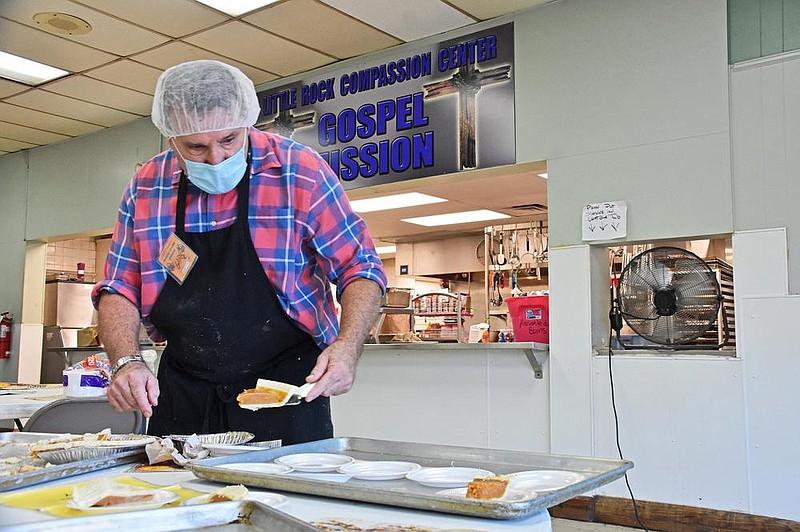 Gary Davidson, a volunteer, puts slices of pumpkin pie on dessert plates Thursday while preparing for the Little Rock Compassion Center’s traditional Thanksgiving dinner. The Compassion Center will continue serving and distributing nearly 9 tons of food over the weekend. More photos at arkansasonline.com/1127thanksgiving/.
(Arkansas Democrat-Gazette/Staci Vandagriff)