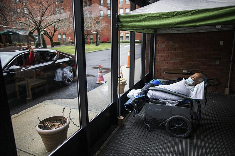 Family members wave goodbye to nursing home resident Barbara Farrior, 85, on Thursday at the end of their visit at the Hebrew Home at Riverdale in New York. The home offered drive-up visits for families of residents struggling with celebrating the holiday alone.
(AP/Eduardo Munoz Alvarez)