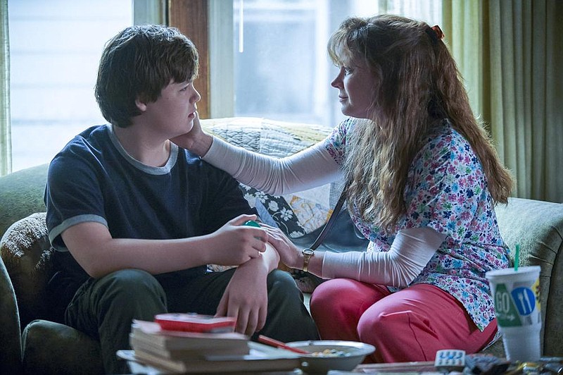 The young J.D. Vance (Owen Asztalos) is alternately comforted and abused by his bipolar mother, Bev (Amy Adams), in “Hillbilly Elegy.”