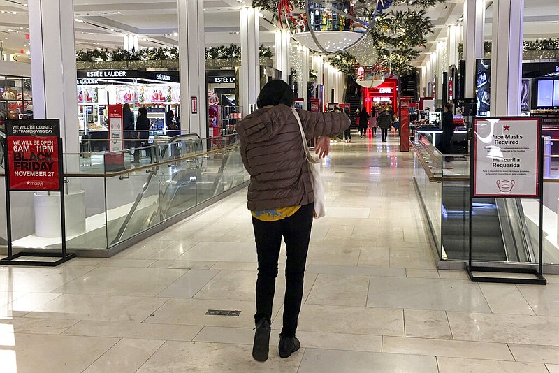 A shopper walks through Macy's flagship store at Herald Square an hour after its 6a.m. Black Friday opening, Friday, Nov. 27, 2020, in New York. (AP Photo/Anne D'Innocenzio)