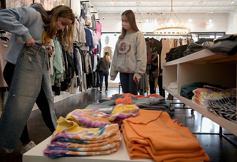 Whitney Hines (left) and Paris Joslin shop for clothes Friday during a Black Friday sale at Steamroller Blues on Kavanaugh Boulevard in Little Rock. While fewer shoppers were out across the country, Thanksgiving Day shopping hit a record in online sales as spending reached $5.1 billion, up 21.5% compared with a year ago.
(Arkansas Democrat-Gazette/Stephen Swofford)