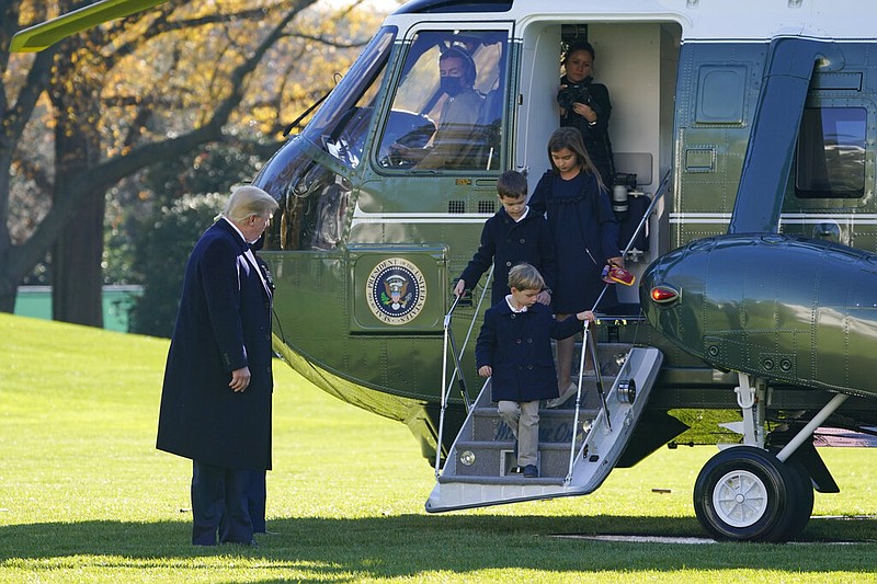 President Donald Trump watches as his grandchildren, Theodore Kushner, Joseph Kushner and Arabella Kushner, step off Marine One on the South Lawn of the White House in Washington on Sunday, Nov. 29, 2020. Trump returned from Camp David on Sunday with his daughter and son-in-law, Ivanka Trump and Jared Kushner, and their children.