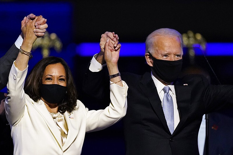 In this Nov. 7, 2020, file photo Vice President-elect Kamala Harris holds hands with President-elect Joe Biden and her husband Doug Emhoff as they celebrate in Wilmington, Del.  (AP Photo/Andrew Harnik, File)

