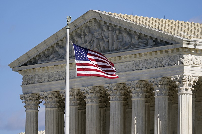 In this Nov. 2, 2020, file photo an American flag waves in front of the Supreme Court building on Capitol Hill in Washington. The Supreme Court is hearing arguments over whether the Trump administration can exclude people in the country illegally from the count used for divvying up congressional seats.