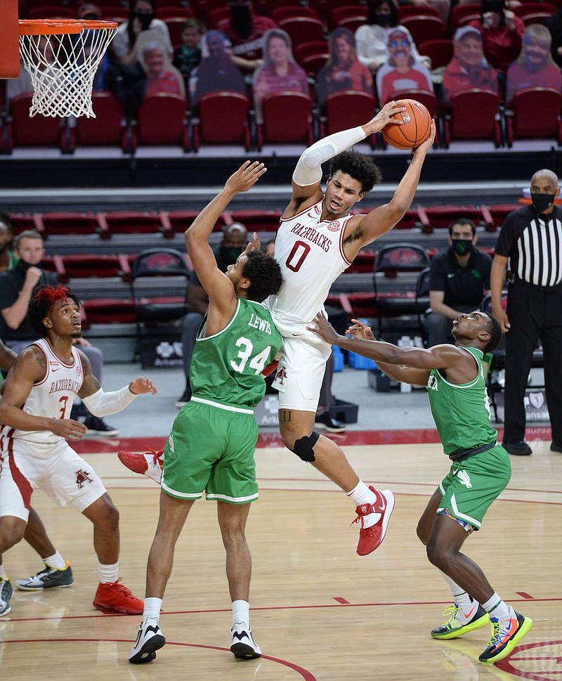 Arkansas forward Justin Smith (0) pulls down a rebound Saturday, Nov. 28, 2020, over North Texas forward Terrence Lewis II (34) during the first half in Bud Walton Arena. Visit nwaonline.com/201129Daily/ for today's photo gallery. 
(NWA Democrat-Gazette/Andy Shupe)