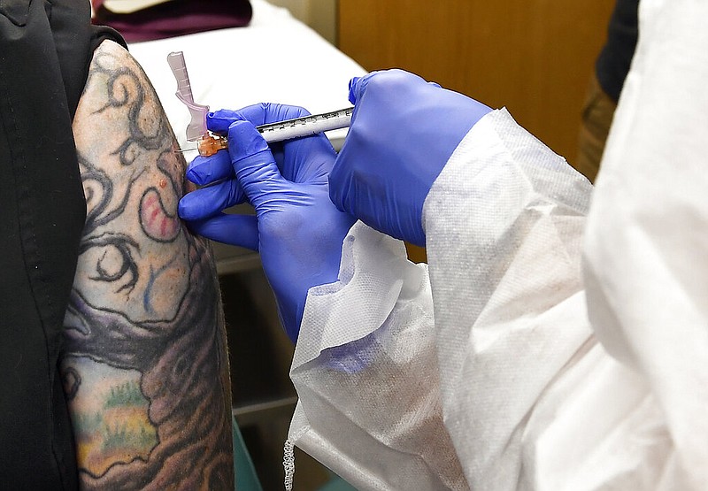 FILE - In this July 27, 2020, file photo, Nurse Kathe Olmstead, right, gives volunteer Melissa Harting, of Harpursville, N.Y., an injection as a study of a possible covid-19 vaccine, developed by the National Institutes of Health and Moderna Inc., gets underway in Binghamton, N.Y.