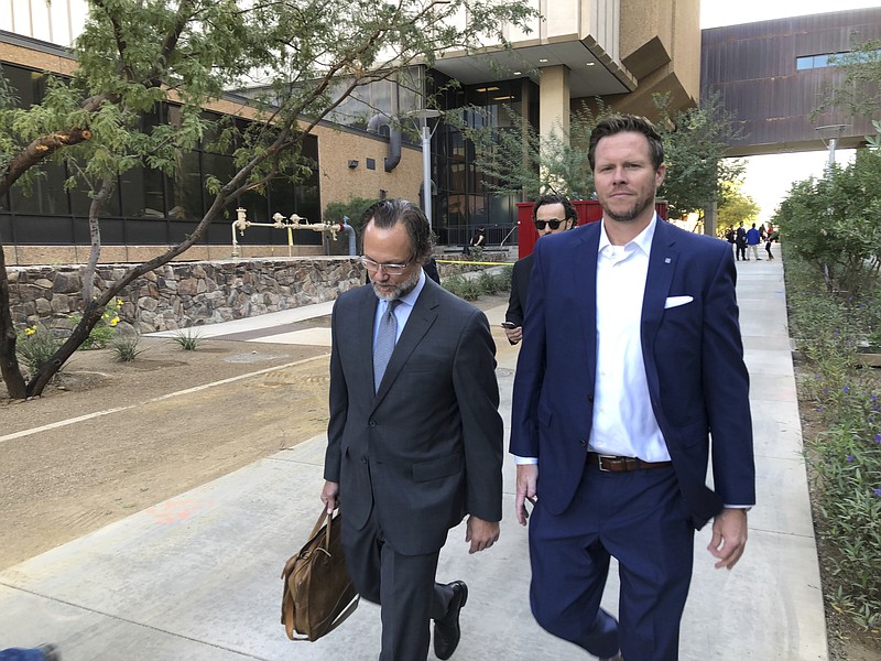 FILE - In this Nov. 5, 2019 file photo, former Maricopa County Assessor Paul Petersen, right, with his attorney, Kurt Altman, leave after a court hearing in Phoenix. Petersen, who admitted running an illegal adoption scheme in three states involving women from the Marshall Islands, was sentenced in Arkansas to six years in federal prison on Tuesday, Dec. 1, 2020. It was the first of three punishments he’ll face for arranging adoptions prohibited by an international compact. 