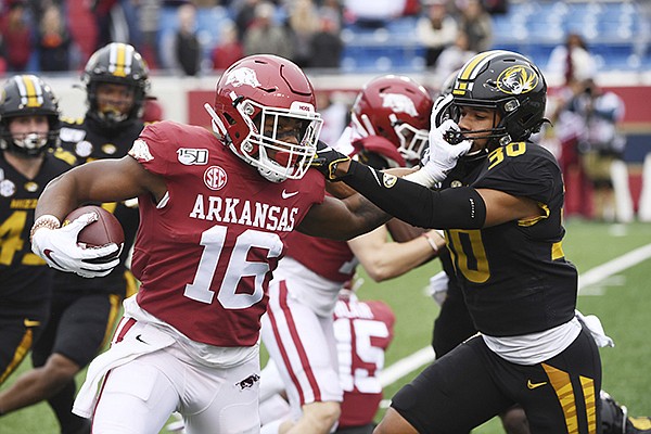 Arkansas receiver Treylon Burks gives Missouri defender Zion Sales a stiff arm as he returns a kick off against during an NCAA college football game, Friday, Nov. 29, 2019 in Little Rock. (AP Photo/Michael Woods)