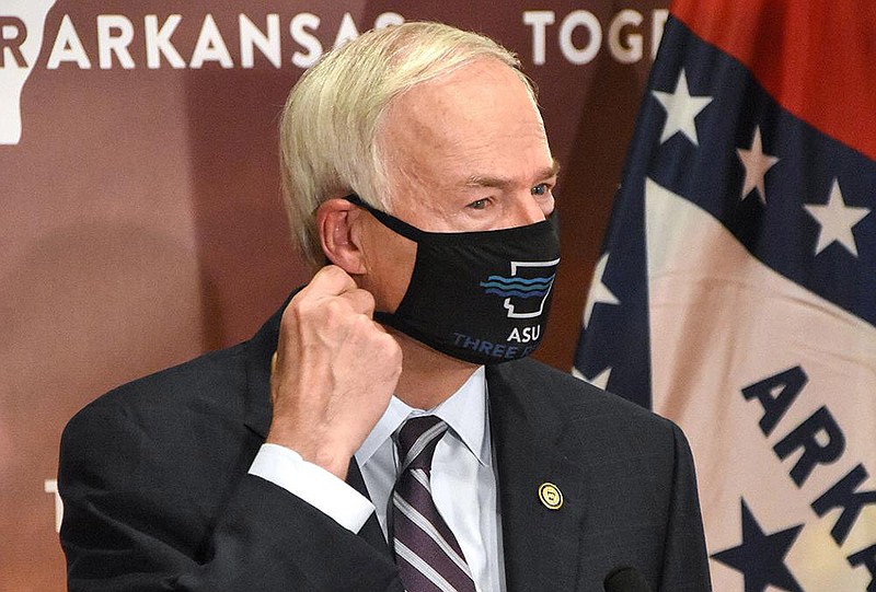 Gov. Asa Hutchinson removes his mask before giving a coronavirus update at the state Capitol. Hutchinson said he’s considering tightening a Health Department directive covering indoor events such as weddings, concerts and plays, as well as movie theaters and other entertainment venues. More photos at arkansasonline.com/124gov/.
(Arkansas Democrat-Gazette/Staci Vandagriff)
