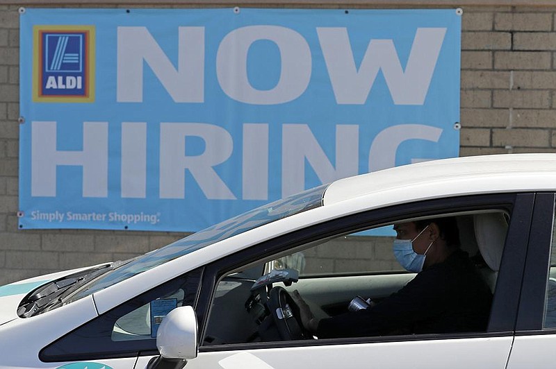 An Aldi grocery store in Morton Grove, Ill., advertises job openings in May. The number of Americans applying for unemployment benefits fell last week to a still-high 712,000, the latest sign that the U.S. economy and job market remain under stress.
(AP/Nam Y. Huh)