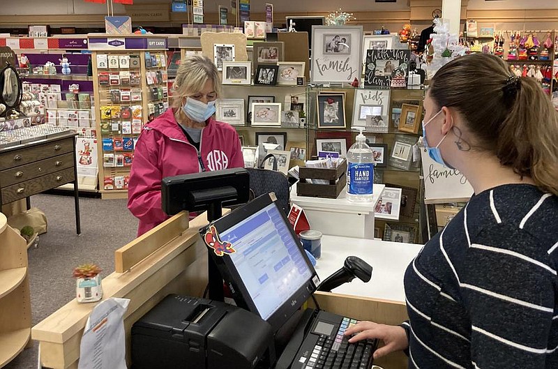 Dee Roberts (left) of Sheridan stops in to buy a few Christmas gifts Thursday at June’s Hallmark Shop in Oak Park Village Shopping Center in Pine Bluff. Jayme Varnell (right) said sales have been strong, and the business has been crowded with shoppers at various times of the day. 
(Pine Bluff Commercial/Byron Tate)