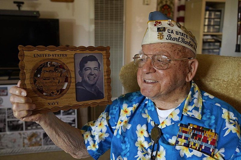 Mickey Ganitch, a survivor of the 1941 attack on Pearl Harbor, is shown in November holding a plaque with a picture of himself as a young sailor, while sitting in his home in San Leandro, Calif. The 101-year-old has traveled to Hawaii for the anniversary of the attack almost every year of the past 15 to remember those killed. But this year, nearly eight decades after the bombing that launched the U.S. into World War II, the coronavirus pandemic is forcing him to observe the moment from afar in California.
(AP/Eric Risberg)