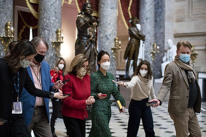 Reporters surround House Speaker Nancy Pelosi (third from left) as she walks to her office Thursday on Capitol Hill. She and Senate Majority Leader Mitch McConnell held their first talks since the Nov. 3 election as support grew for a bipartisan coronavirus relief bill.
(The New York Times/Al Drago)