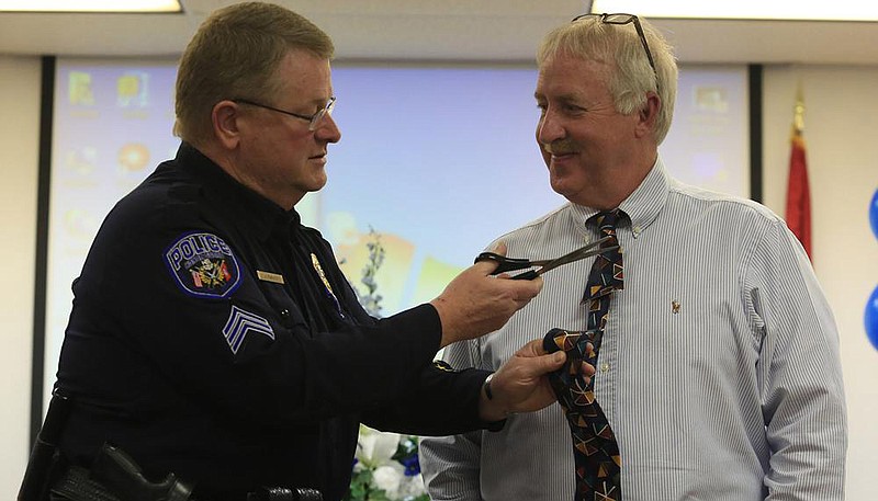 In this photo from March 26, 2013, North Little Rock police Sgt. J.L. “Buck” Dancy snips the tie of Lt. Jerry Smith during a retirement ceremony for Smith and Capt. Donnie Bridges. Dancy died Wednesday from covid-19.
(Democrat-Gazette file photo)