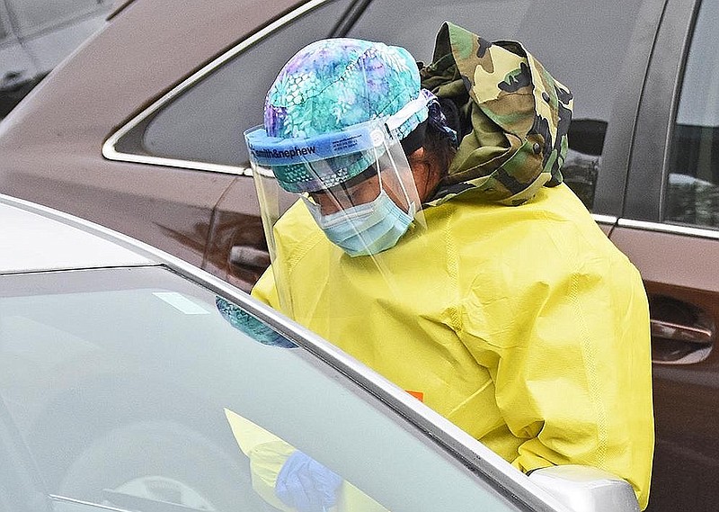 Barbara McDonald, an advanced practice registered nurse for UAMS, screens patients Thursday, Dec. 3, 2020 during a drive-thru covid-19 testing at the Lonoke Community Center. (Arkansas Democrat-Gazette/Staci Vandagriff)