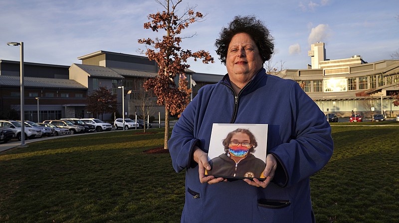 Laura Dilts, of Barre, Mass., holds a photograph of her 16-year-old son outside the Worcester Recovery Center, where he is a resident patient receiving assistance for his mental health, Monday, Nov. 23, 2020, in Worcester, Mass. The coronavirus pandemic has led to rising emergency room visits and longer waits for U.S. children and teens facing mental health issues. (AP Photo/Charles Krupa)