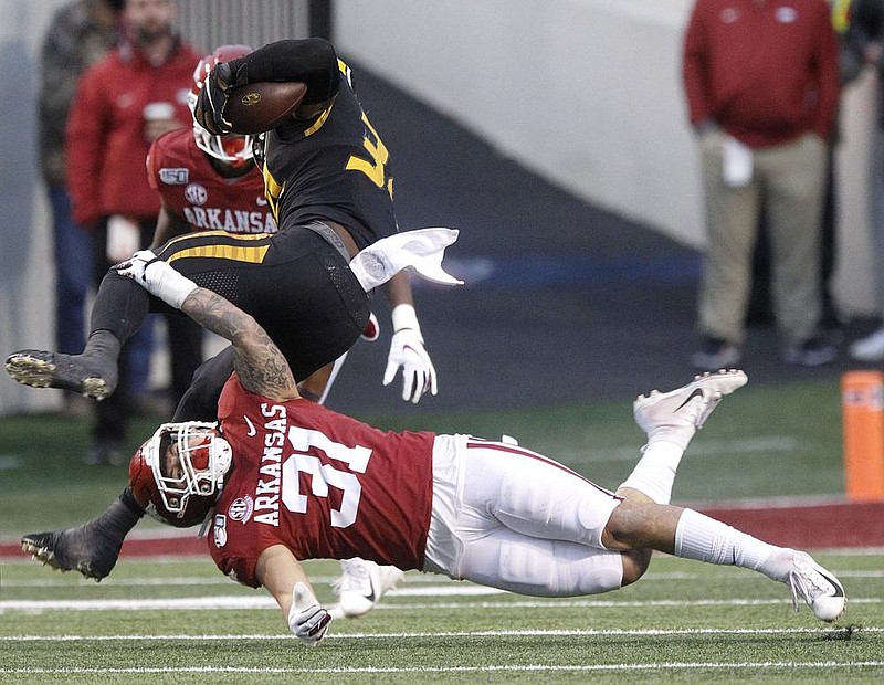 Arkansas linebacker Grant Morgan (31) attempts to trip up Missouri running back Larry Rountree during the Razorbacks’ 24-14 loss last season in Little Rock. Both players fi gure to play when the teams meet today in Columbia, Mo. Arkansas will attempt to end a losing streak in its “trophy games” — against Missouri, LSU and Texas A&M — which stretches to 2015.
(Arkansas Democrat-Gazette/Thomas Metthe)