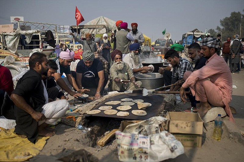 Activist farmers in India prepare flatbread earlier this week for fellow farmers as they block a highway during a protest against new farming laws they say will result in exploitation by corporations.
(AP/Altaf Qadri)