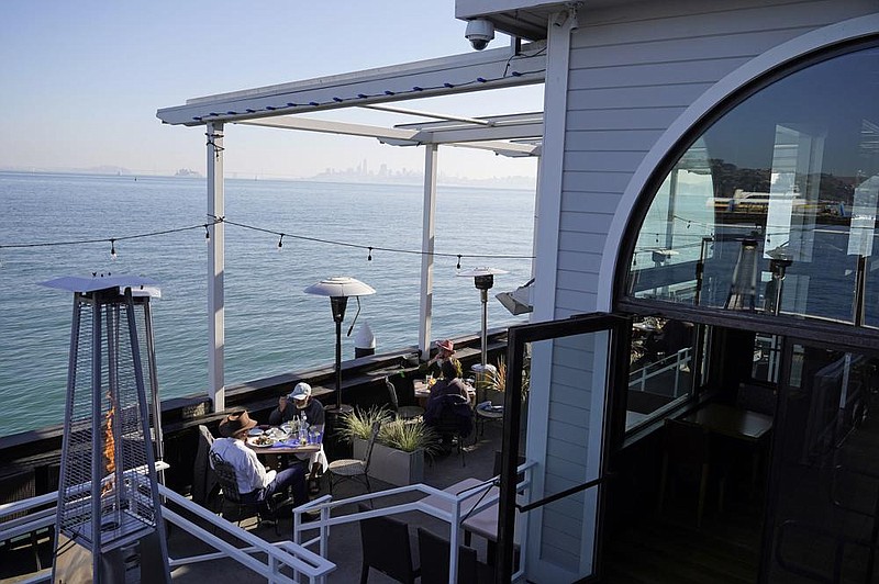 People dine outdoors Friday at The Trident restaurant in Sausalito, Calif. Health officers in six San Francisco Bay Area regions have issued a new stay-at-home order beginning Sunday night and running through Jan. 4, effectively closing many businesses.
(AP/Eric Risberg)