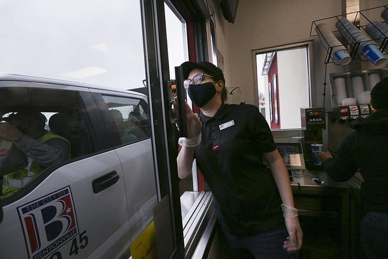 Crew member Lilly Harris completes a drive-thru order, Thursday at the new Dairy Queen in Bentonville. Check out nwaonline. com/201204Daily/ for today’s photo gallery. (NWA Democrat-Gazette/Charlie Kaijo) 